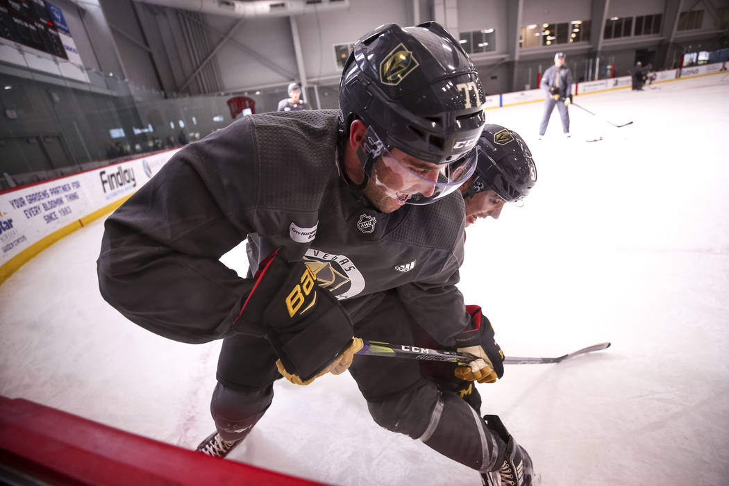 Vegas Golden Knights defenseman Brad Hunt, foreground, and left wing David Perron vie for the puck during the NHL team's practice at the City National Arena in Las Vegas, Wednesday, Dec. 6, 2017. ...