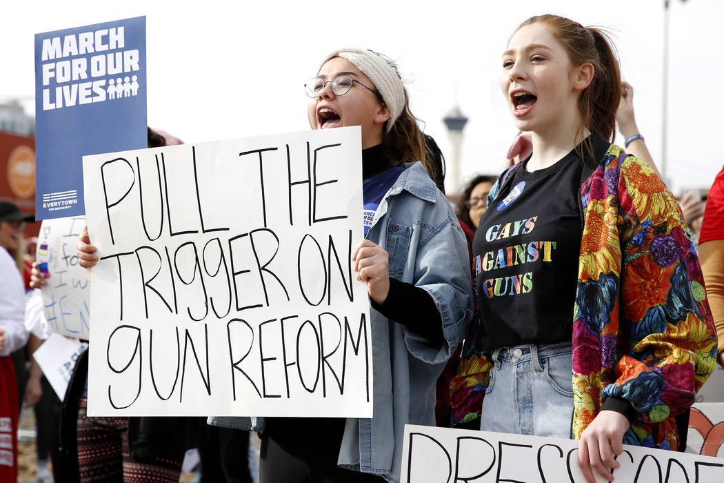 Juliette Singer, a 17-year-old student from the Las Vegas Academy, left, and Emma Tatum, a 17-year-old student from Nevada State High School, practice chants before the start of the Las Vegas Marc ...