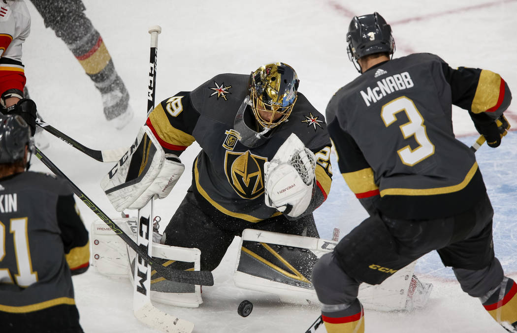 Vegas Golden Knights goaltender Marc-Andre Fleury (29) looks to grab the puck as defenseman Brayden McNabb (3) stands by during the first period of an NHL hockey game between the Golden Knights an ...