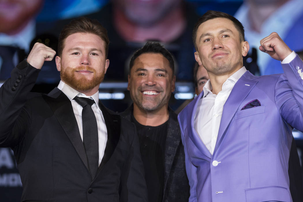 Boxers Saul "Canelo" Alvarez, left, and Gennady Golovkin, right, during their press conference with boxing promoter Oscar De La Hoya, at Microsoft Square in Los Angeles, Calif., Tuesday, Feb. 27,  ...