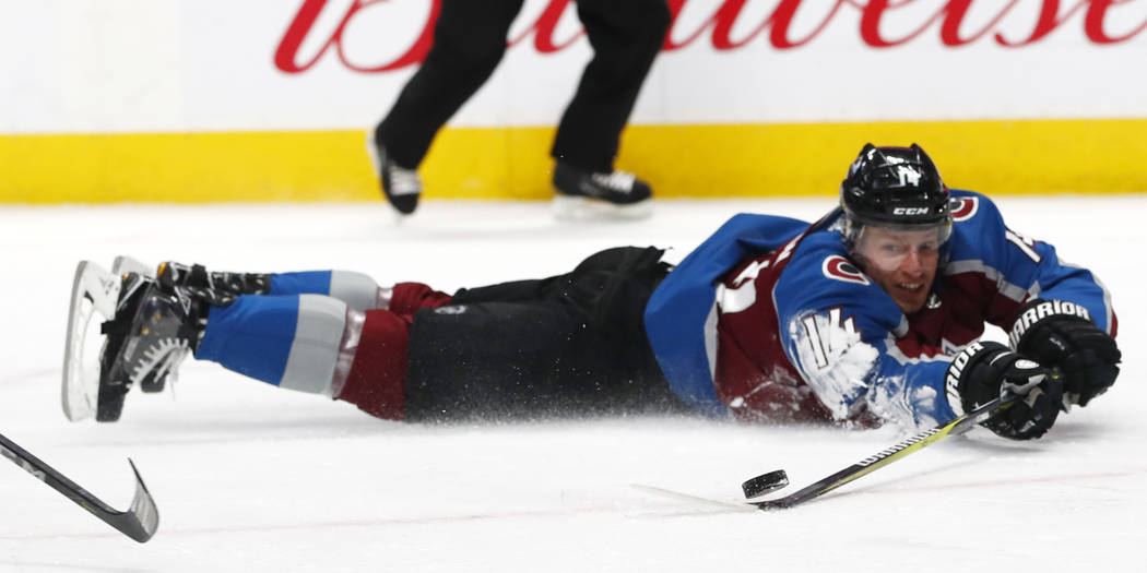 Colorado Avalanche left wing Blake Comeau tries to shoot the puck as he slides across the ice against the Vegas Golden Knights in the third period of an NHL hockey game Saturday, March 24, 2018, i ...