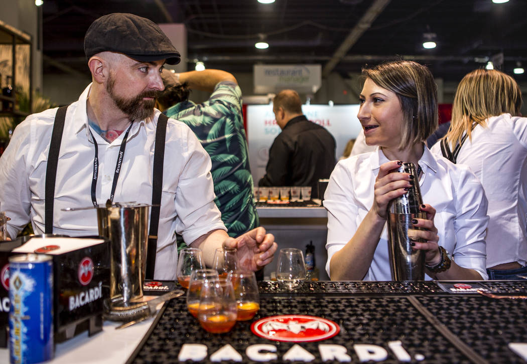 Bacardi bartenders Jimmy McGowan and Jessica Fitzmeyer share a moment while preparing drinks during the Nightclub and Bar Show at the Las Vegas Convention Center on Tuesday, March 27, 2018. Patri ...