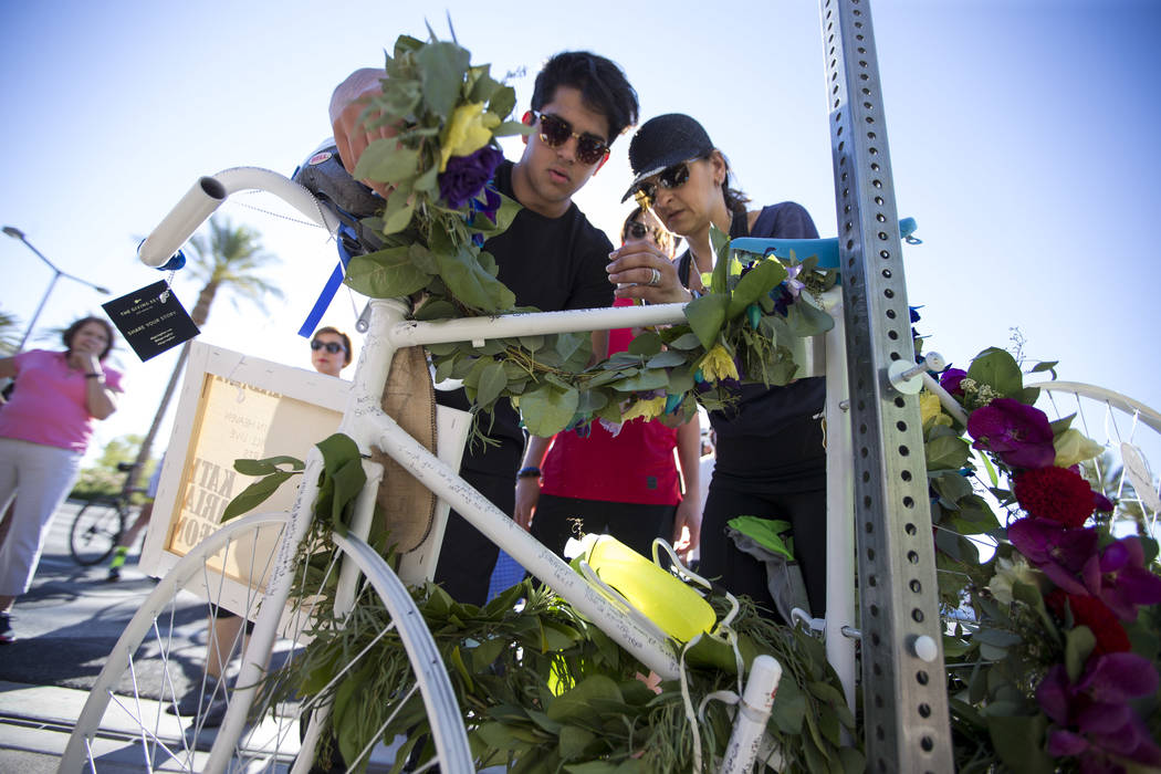 Dr. Kayvan Khiabani's widow Katy Barin, right, and her son Aria Khiabani, 16, leave a wreath on the ghost bike of Khiabani during a memorial service at the corner South Pavillion Center Drive near ...