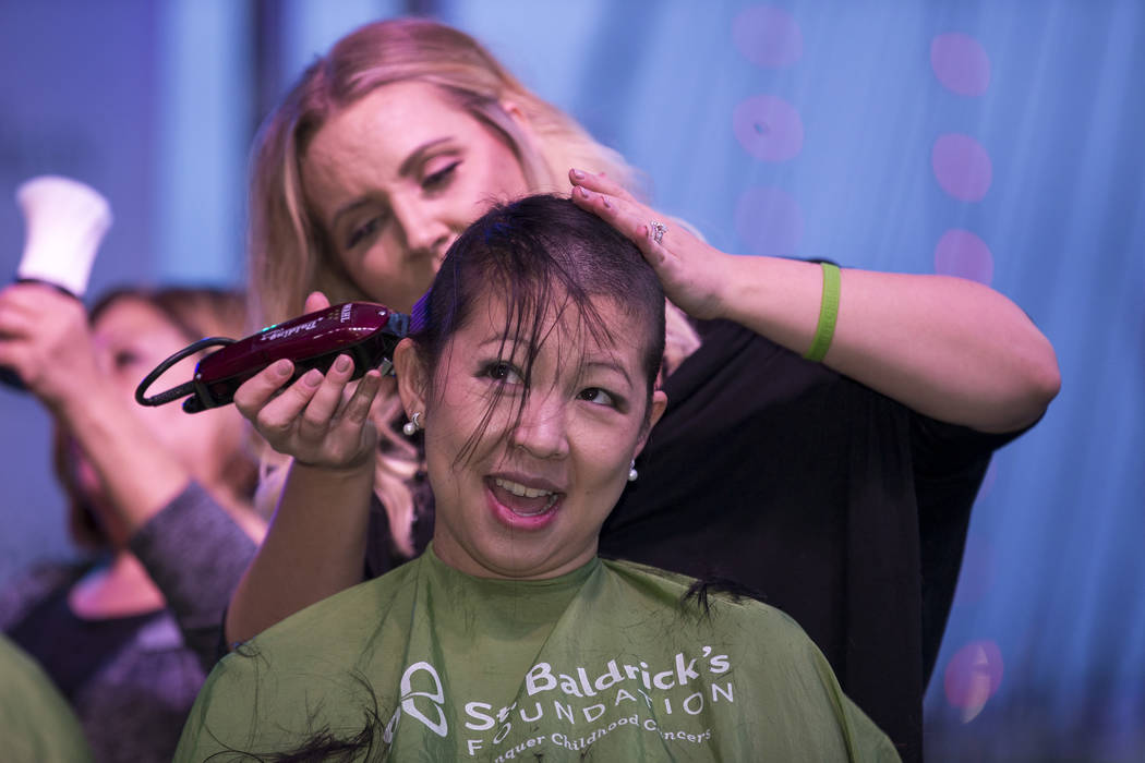 Cancer survivor and Las Vegas local Lisa King, 33, shaves her head during a St. Baldrick's head-shaving event to raise money for childhood cancer research outside the New York-New York on the Las ...