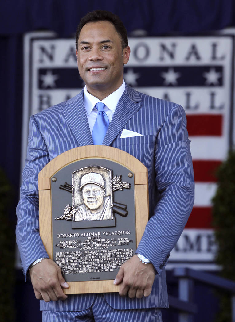 Roberto Alomar holds his plaque after his induction into the Baseball Hall of Fame in Cooperstown, N.Y., on Sunday, July 24, 2011. (AP Photo/Mike Groll)