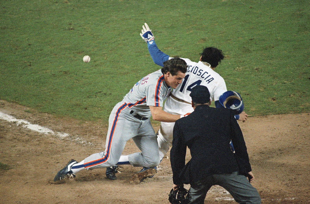 New York Mets Kevin McReynolds, left, is blocked by Los Angeles Dodger catcher Mike Scioscia (14) as he makes his way to home plate during ninth inning action in the first game of the NL Champions ...