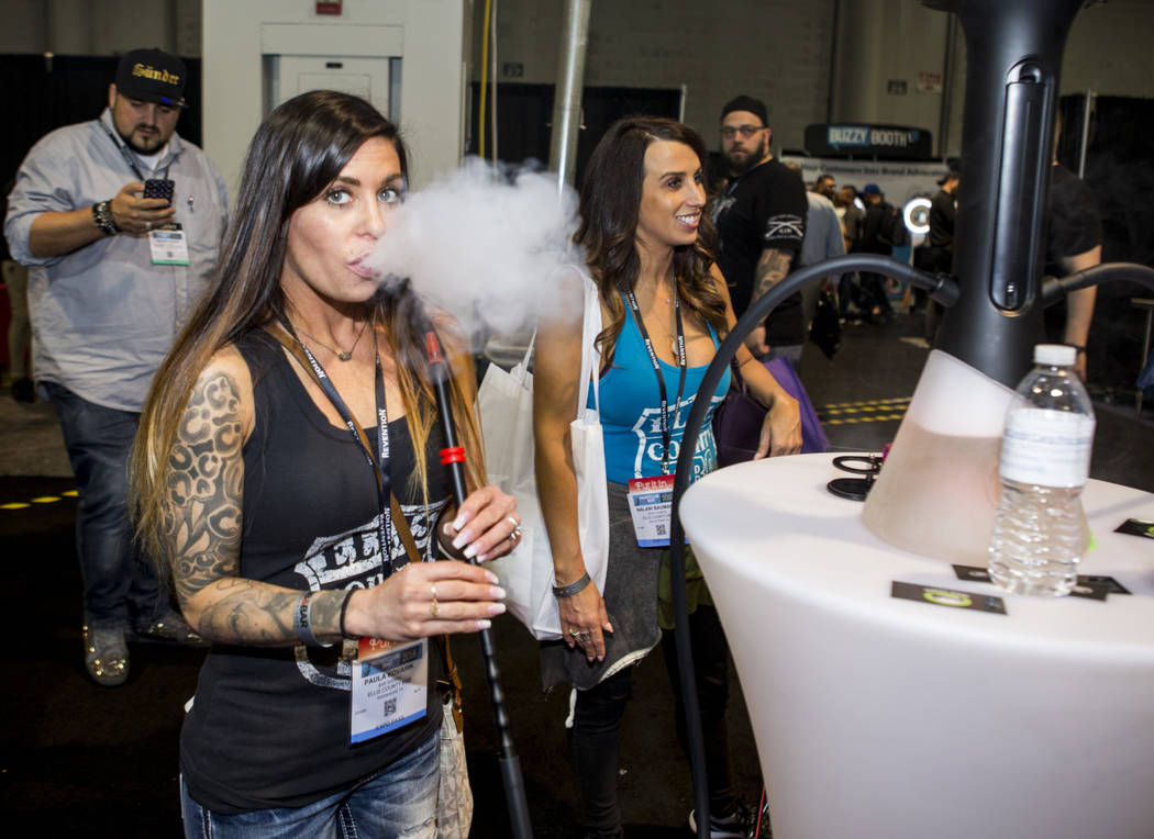 Paula Kovarik of Waxahachie, Texas, tries out a rig from O2 Hookah during the Nightclub and Bar Show at the Las Vegas Convention Center on Tuesday, March 27, 2018.  Patrick Connolly Las Vegas Revi ...