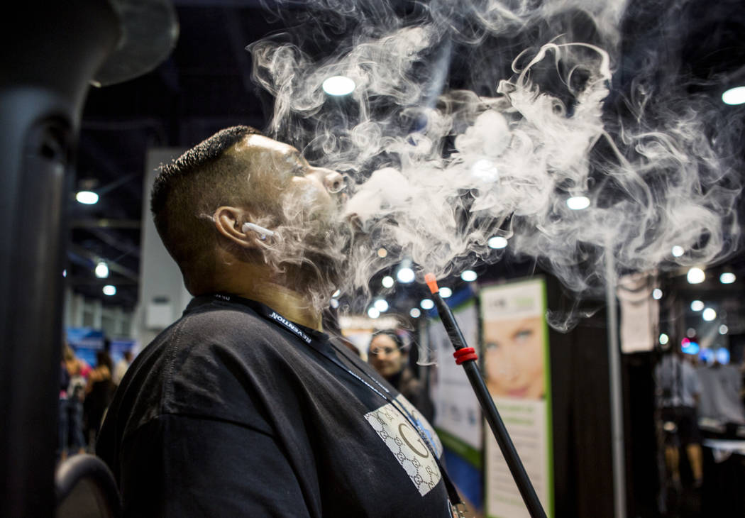 Sunny Patel, owner of Xhale Bar and Lounge near Lake Tahoe, tries out an electronic hookah rig from O2 Hookah during the Nightclub and Bar Show at the Las Vegas Convention Center on Tuesday, March ...
