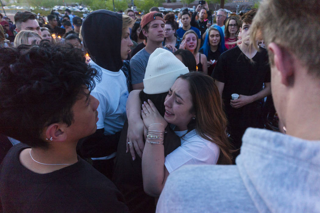 Allie Rossi, right, mourns the loss of her brother, Albert "A.J." Rossi, while hugging Alexis Vargas during a candlelight vigil at Knickerbocker Park in Las Vegas Friday, March 30, 2018. ...