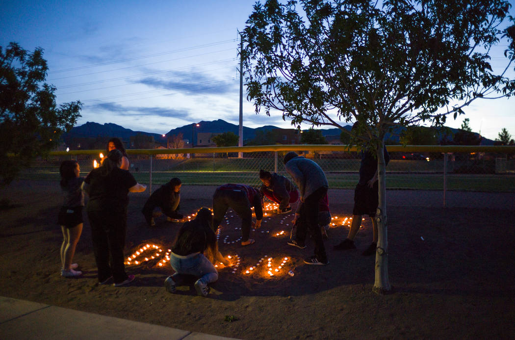 Attendees lay out candles following a vigil at Knickerbocker Park in Las Vegas Friday, March 30, 2018 for Centennial High School students Albert " A.J." Rossi, Dylan Mack and Brooke Hawl ...