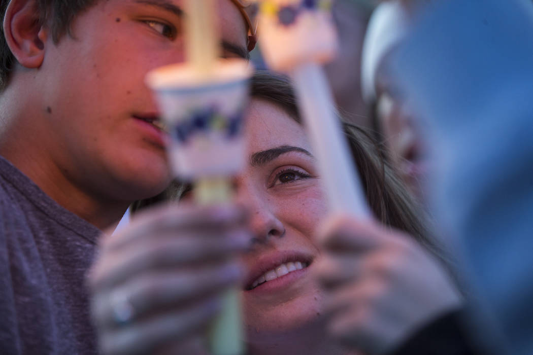 Allie Rossi, center, is comforted by Brennan Mecke while mourning the loss of her brother, Albert "A.J." Rossi, during a candlelight vigil at Knickerbocker Park in Las Vegas Friday, Marc ...