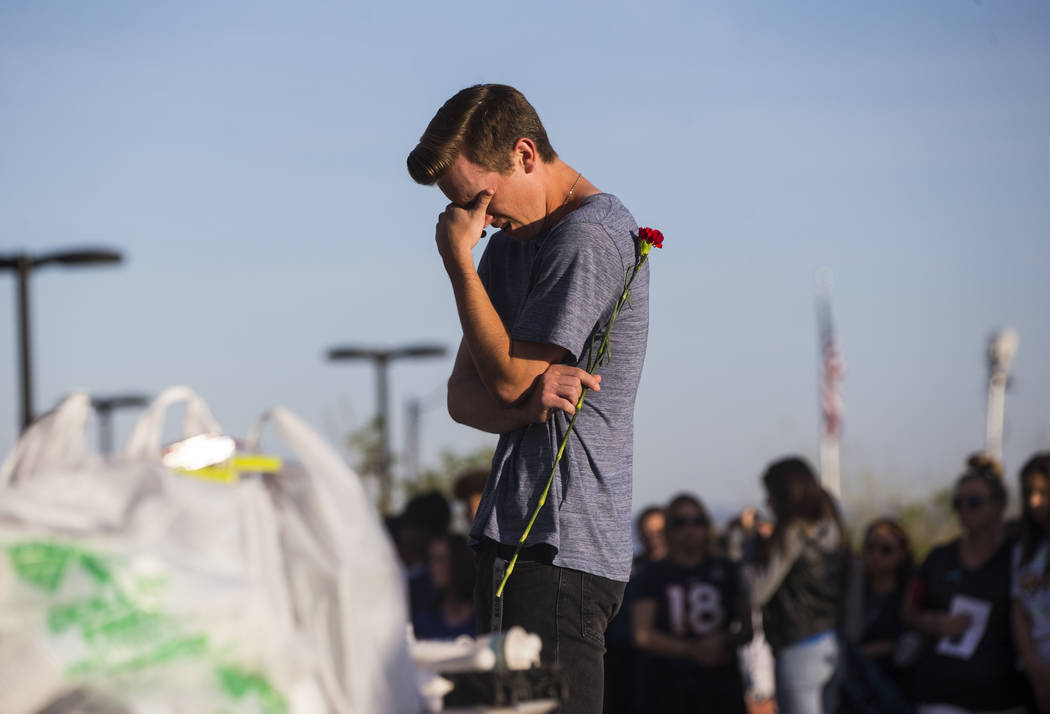 An attendee reacts during a candlelight vigil at Knickerbocker Park in Las Vegas Friday, March 30, 2018 for Centennial High School students Albert ÒA.J.Ó Rossi, Dylan Mack and Brooke Haw ...