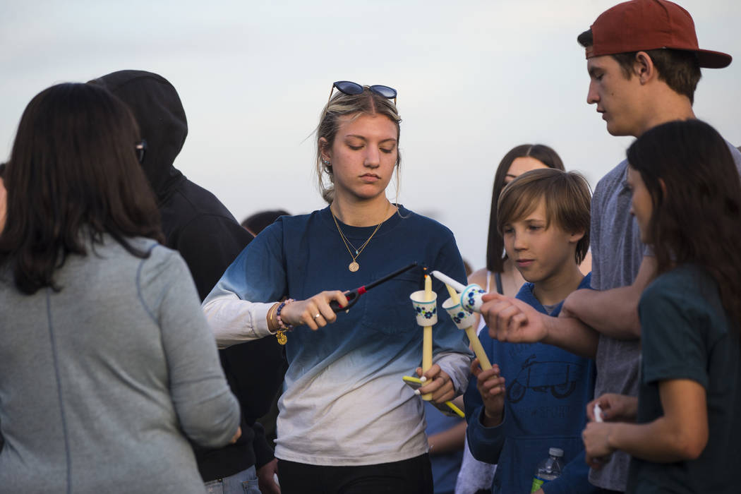 Attendees light candles during a candlelight vigil at Knickerbocker Park in Las Vegas Friday, March 30, 2018 for Centennial High School students Albert ÒA.J.Ó Rossi, Dylan Mack and Brook ...