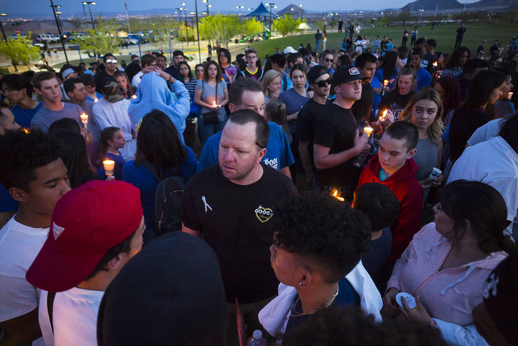Morgan Mack, center, talks with friends and classmates of his son, Dylan Mack, during a candlelight vigil at Knickerbocker Park in Las Vegas Friday, March 30, 2018. Dylan Mack, along with fellow C ...