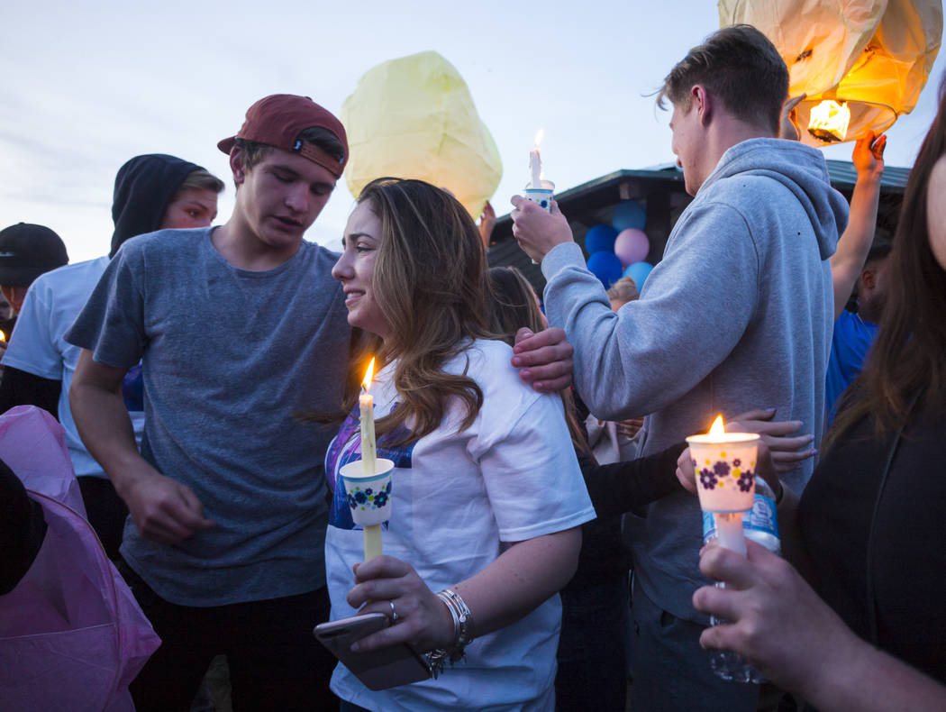Allie Rossi, center, is comforted by Brennan Mecke while mourning the loss of her brother, Albert "A.J." Rossi, during a candlelight vigil at Knickerbocker Park in Las Vegas Friday, Marc ...