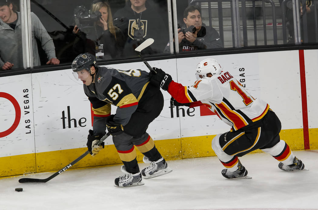 Vegas Golden Knights left wing David Perron (57) controls the puck as Calgary Flames center Mikael Backlund (11) follows behind during the second period of an NHL hockey game at the T-Mobile Arena ...