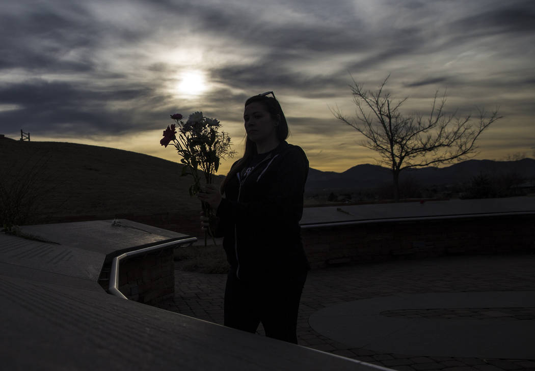 Sierra Evans places flowers on stones honoring victims of the Columbine school shooting on Wednesday, March 14, 2018, at the Columbine Memorial, in Littleton, CO. "We have a beautiful memoria ...