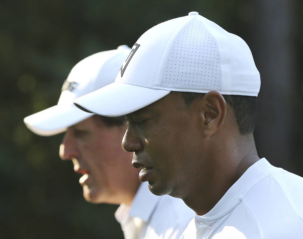 Phil Mickelson, left, and Tiger Woods walk down the 11th fairway while playing a practice round for the Masters golf tournament at Augusta National Golf Club in Augusta, Ga., Tuesday, April 3, 201 ...