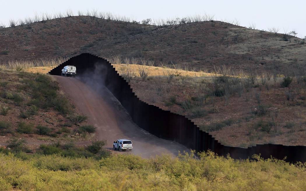 U.S. Border Patrol agents patrol the border fence in Naco, Ariz., on Oct. 2, 2012. National guard contingents in U.S. states that border Mexico say they are waiting for guidance from Washington to ...