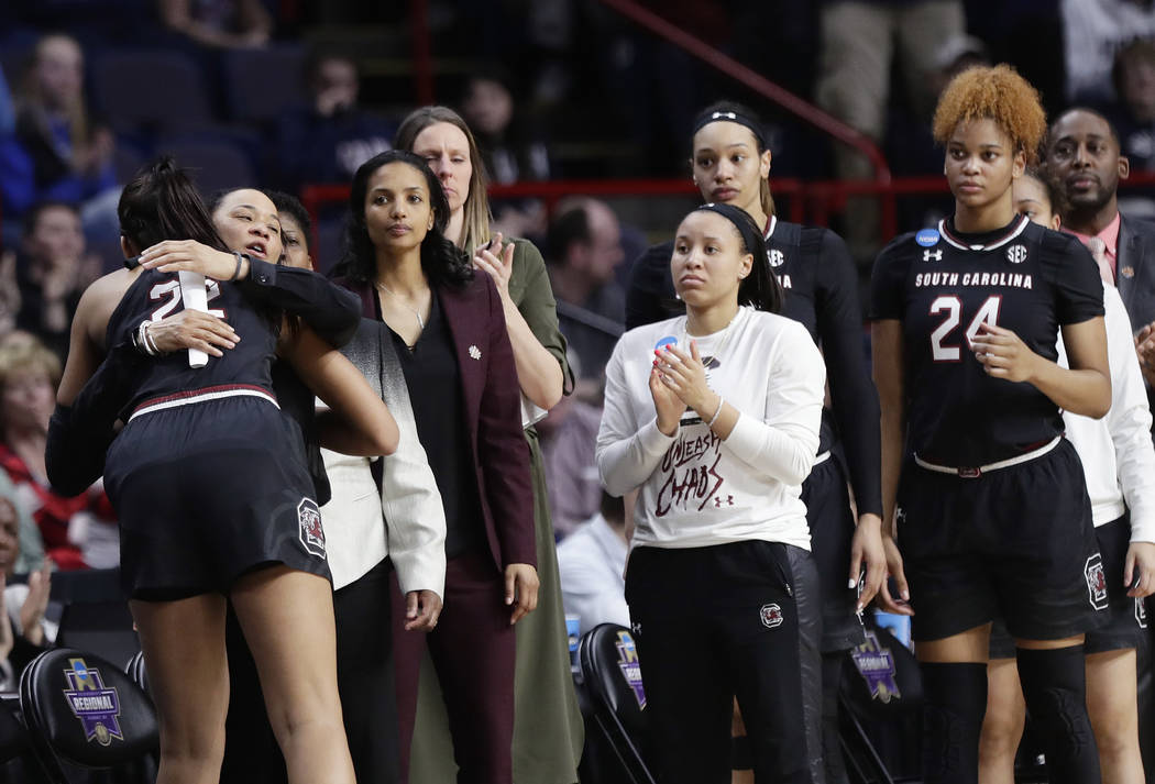 South Carolina head coach Dawn Staley hugs A'ja Wilson, left, as Wilson  leaves the game during the second half of a regional final against  Connecticut at the a women's NCAA college basketball