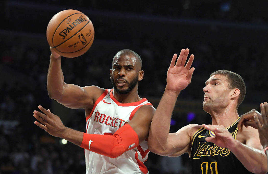 Houston Rockets guard Chris Paul, left, passes the ball as Los Angeles Lakers center Brook Lopez defends during the first half of an NBA basketball game Tuesday, April 10, 2018, in Los Angeles. (A ...