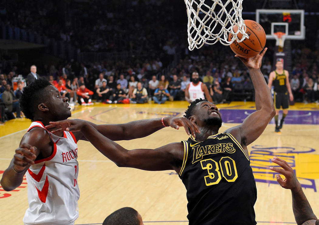 Los Angeles Lakers forward Julius Randle, right, grabs a rebound away from Houston Rockets center Clint Capela during the first half of an NBA basketball game Tuesday, April 10, 2018, in Los Angel ...