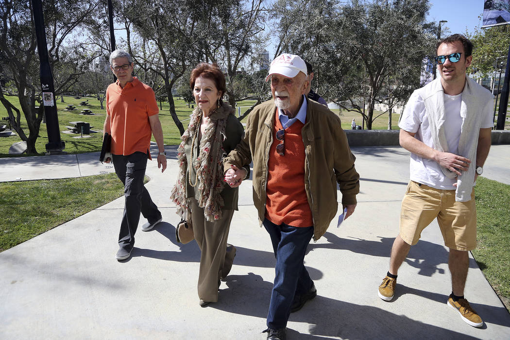 In this Wednesday, April 11, 2018, photo, childhood Holocaust survivors Simon Gronowski, center right, and Alice Gerstel Weit hold hands as they tour the Los Angeles Holocaust Museum. (AP Photo/Re ...