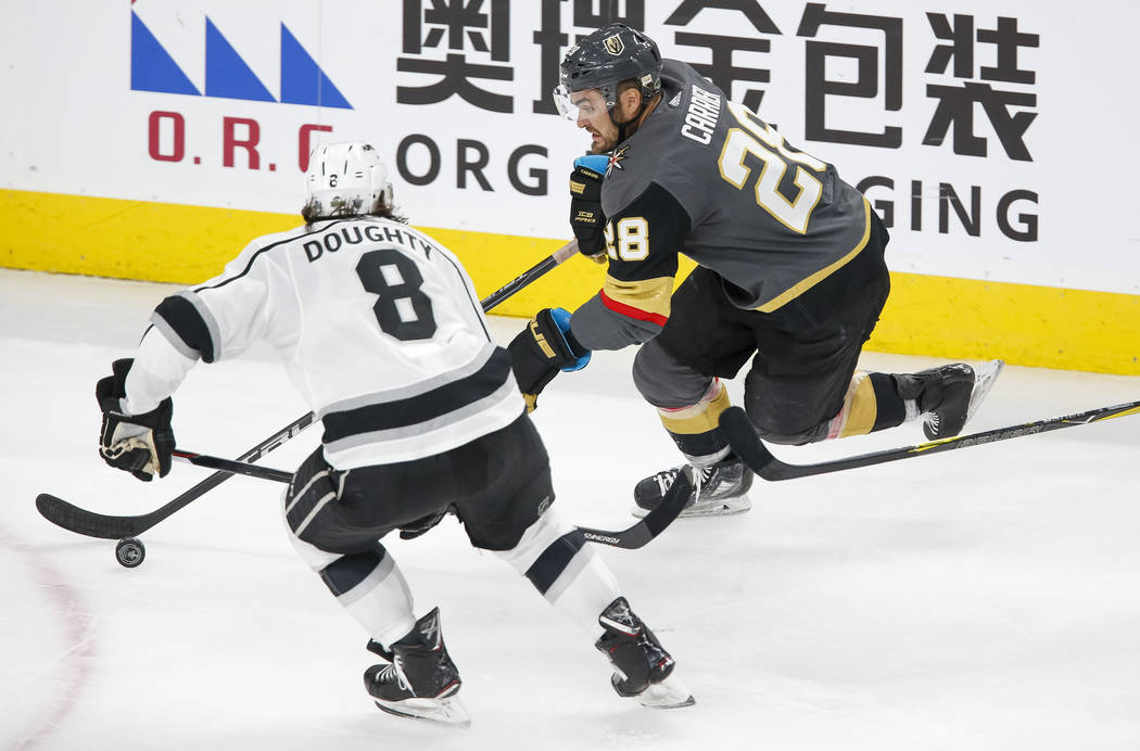 Golden Knights left wing William Carrier (28) skates with the puck as Los Angeles Kings defenseman Drew Doughty (8) closes in during the third period of Game 1 of an NHL hockey first-round playoff ...