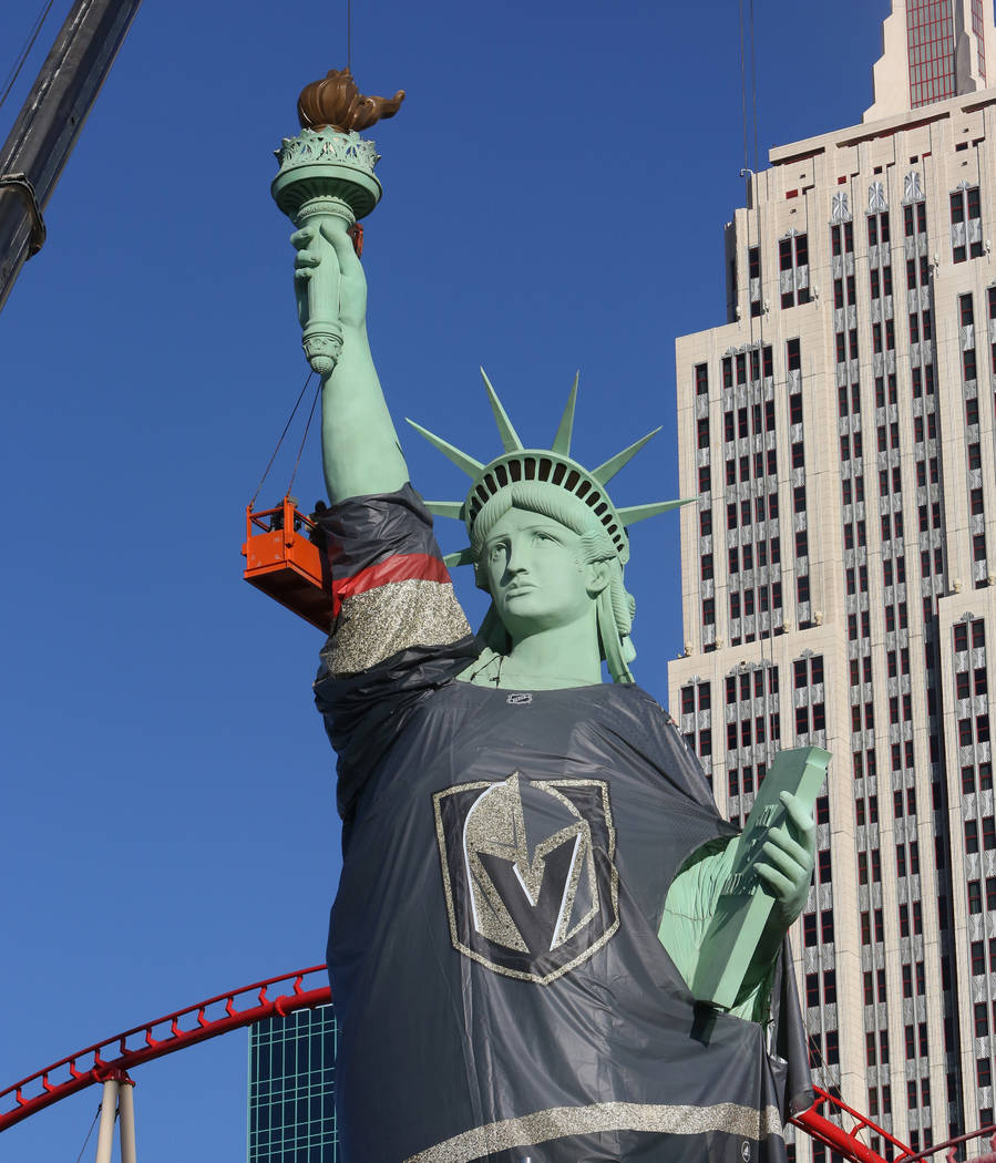 Workers install a Vegas Golden Knights jersey on the Statue of Liberty at New York-New York on Friday, April 13, 2018, on the Las Vegas Strip. (Bizuayehu Tesfaye/Las Vegas Review-Journal) @bizutesfaye