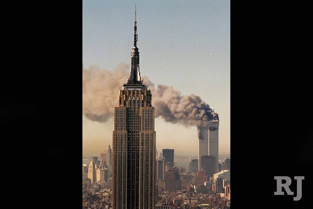 The twin towers of the World Trade Center burn behind New York's Empire State Building in this Sept. 11, 2001 file photo. (Marty Lederhandler/AP)