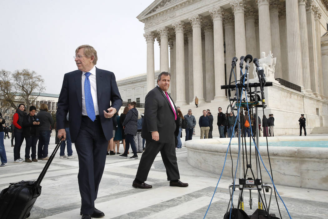 Theodore Olson, left, the lawyer for New Jersey, walks with New Jersey Gov. Chris Christie to attend a news conference after leaving the Supreme Court where a case on sports betting is being heard ...