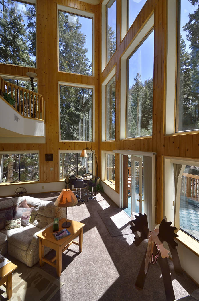The home features a wall of windows to show off the pine forest outside. (Bill Hughes Real Estate Millions)