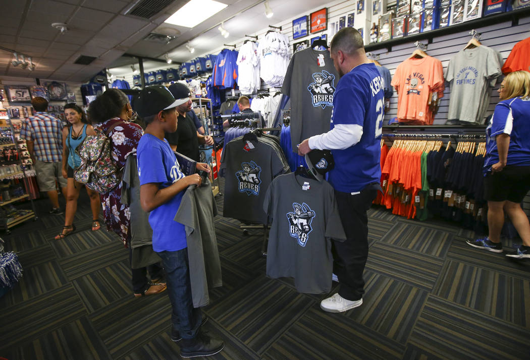 Nine-year-old Antonio Gonzalez, left, and Jesus Gonzalez, look at shirts featuring the special Las Vegas 51s "Reyes de Plata" (Silver Kings) name, part of a new Minor League Baseball in ...