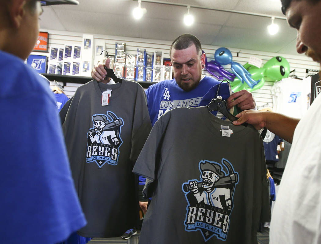 Jesus Gonzalez, center, checks out shirts featuring the special Las Vegas 51s "Reyes de Plata" (Silver Kings) name, part of a new Minor League Baseball initiative, at the team store at C ...