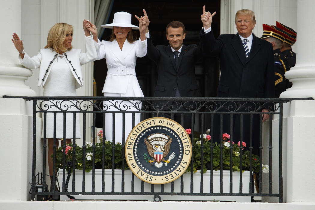 Brigitte Macron, first lady Melania Trump, French President Emmanuel Macron, and President Donald Trump join hands during a State Arrival Ceremony on the South Lawn of the White House, Tuesday, Ap ...