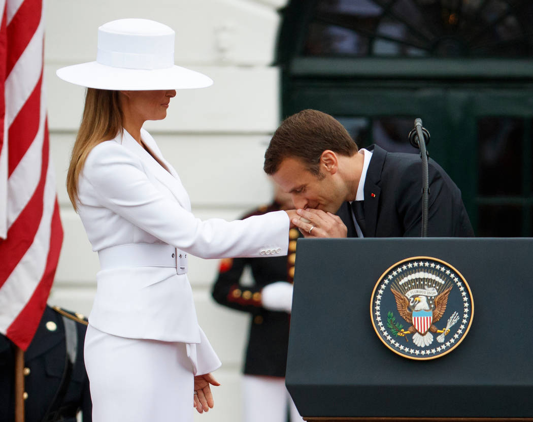French President Emmanuel Macron kisses the hand of first lady Melania Trump during a State Arrival Ceremony on the South Lawn of the White House, Tuesday, April 24, 2018, in Washington. (AP Photo ...