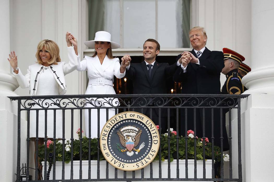 President Donald Trump, French President Emmanuel Macron, first lady Melania Trump and Brigitte Macron hold hands on the White House balcony during a State Arrival Ceremony at the White House in W ...