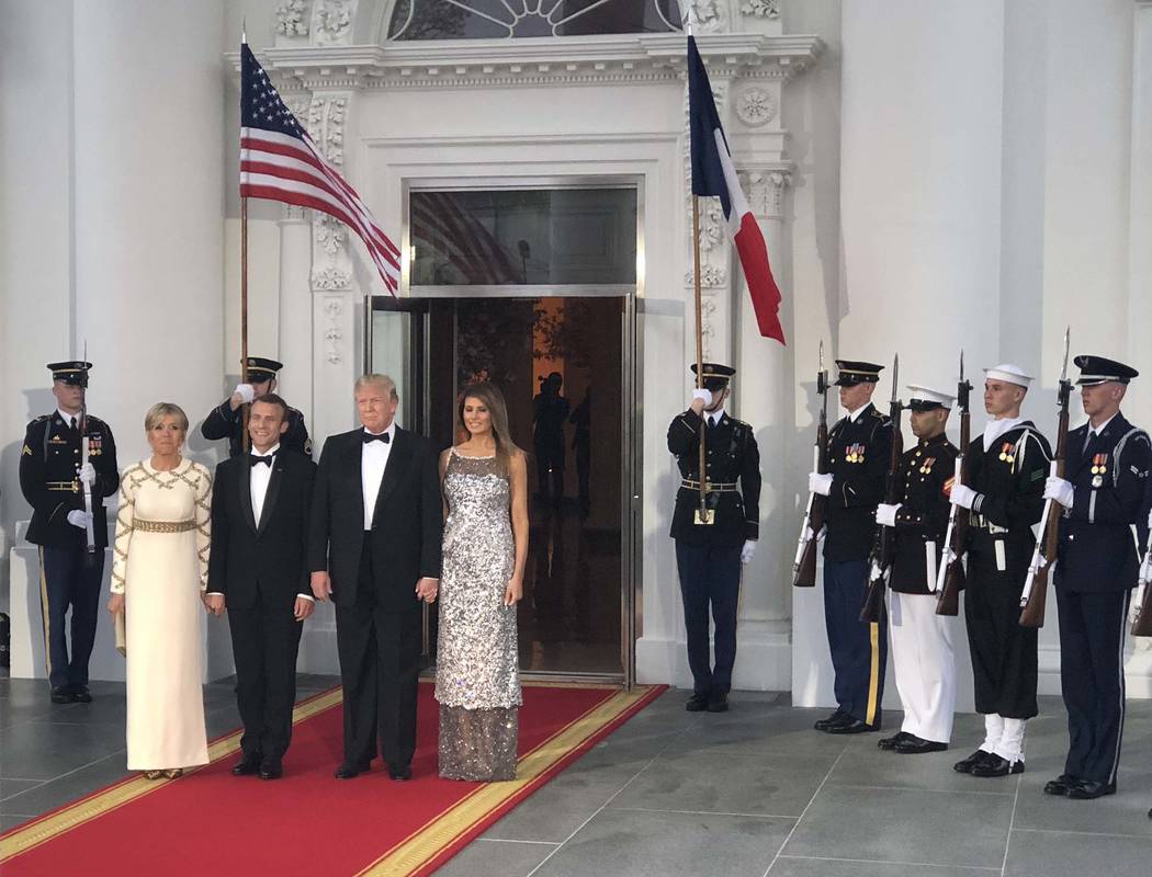President Donald Trump and first lady Melania Trump stand with French President Emmanuel Macron and his wife, Brigitte, at the North Portico of the White House before a state dinner, Tuesday, Apri ...