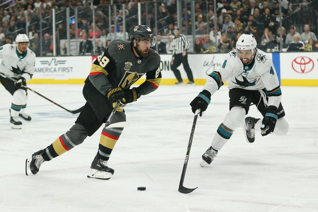 Vegas Golden Knights right wing Alex Tuch (89) and San Jose Sharks defenseman Brenden Dillon (4) go for the puck during the first period in Game 1 of an NHL hockey second-round playoff series at T ...