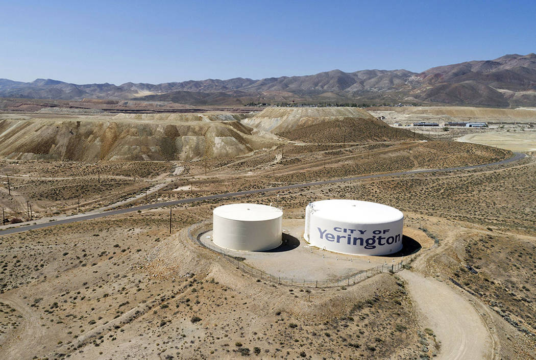 Water tanks for the town of Yerington, with the abandoned Anaconda mine pit, source of an underground plume of poisonous water in the background, are seen Friday. (AP Photo/Scott Sady)