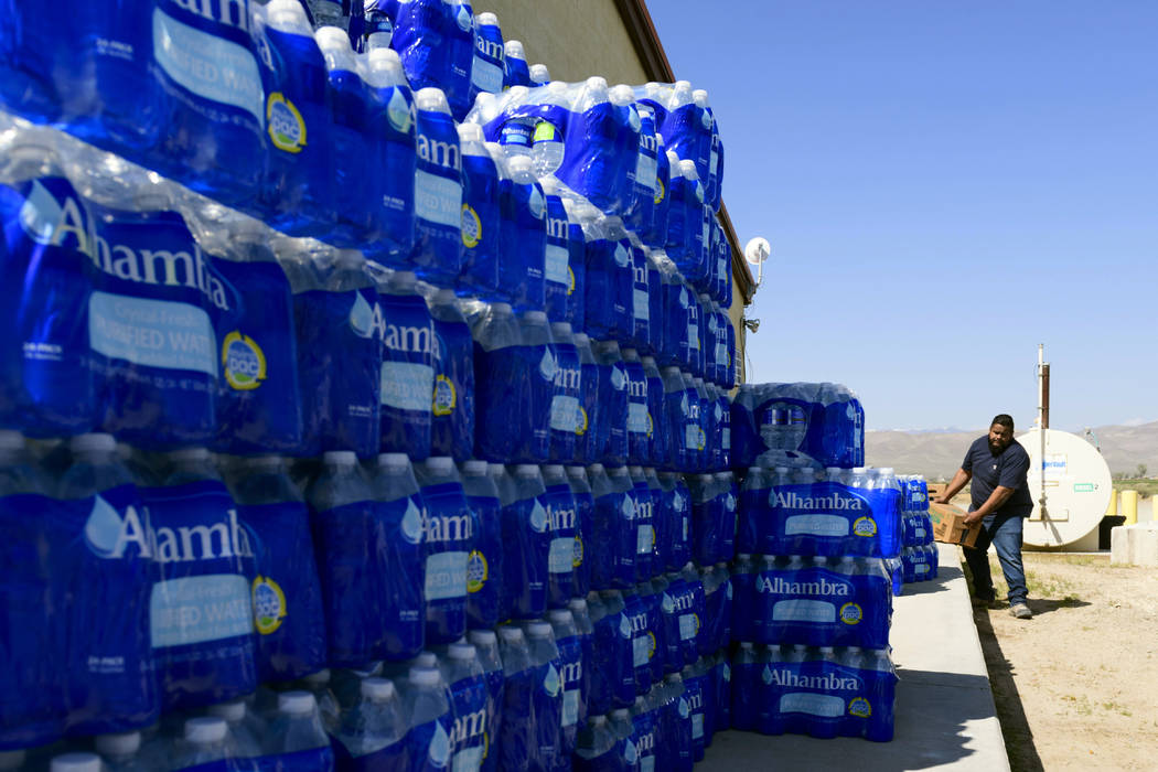 Tommy Gutierrez, a Paiute tribe member, helps load up some of the thousands of plastic water bottles that are distributed weekly to the Yerington Paiute tribe in Yerington on Friday. (AP Photo/Sc ...