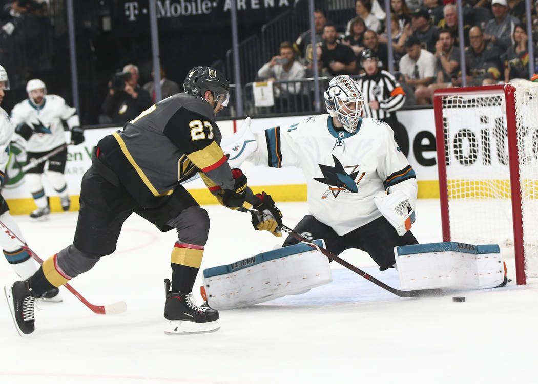 Golden Knights defenseman Shea Theodore (27) tries to get the puck in as San Jose Sharks goaltender Martin Jones (31) defends during the first period of Game 2 of an NHL hockey second-round playof ...