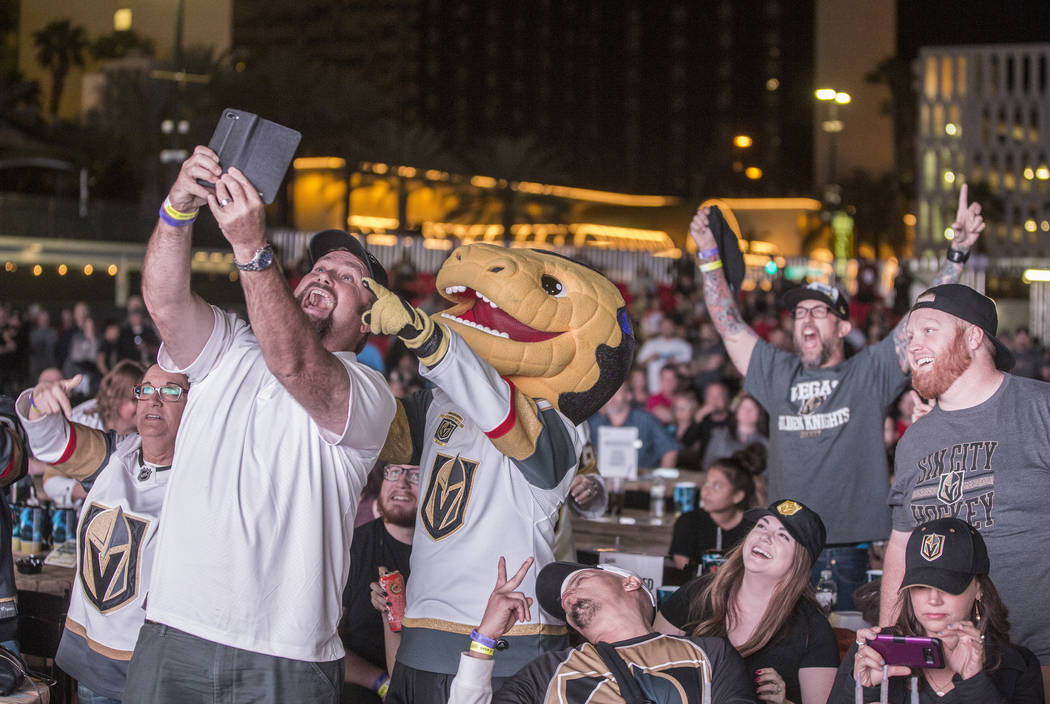 Bernie Lange, left, takes a selfie with Golden Knights mascot Chance after a second period goal at a watch party during game three of Vegas' playoff series with the San Jose Sharks on Monday, Apri ...