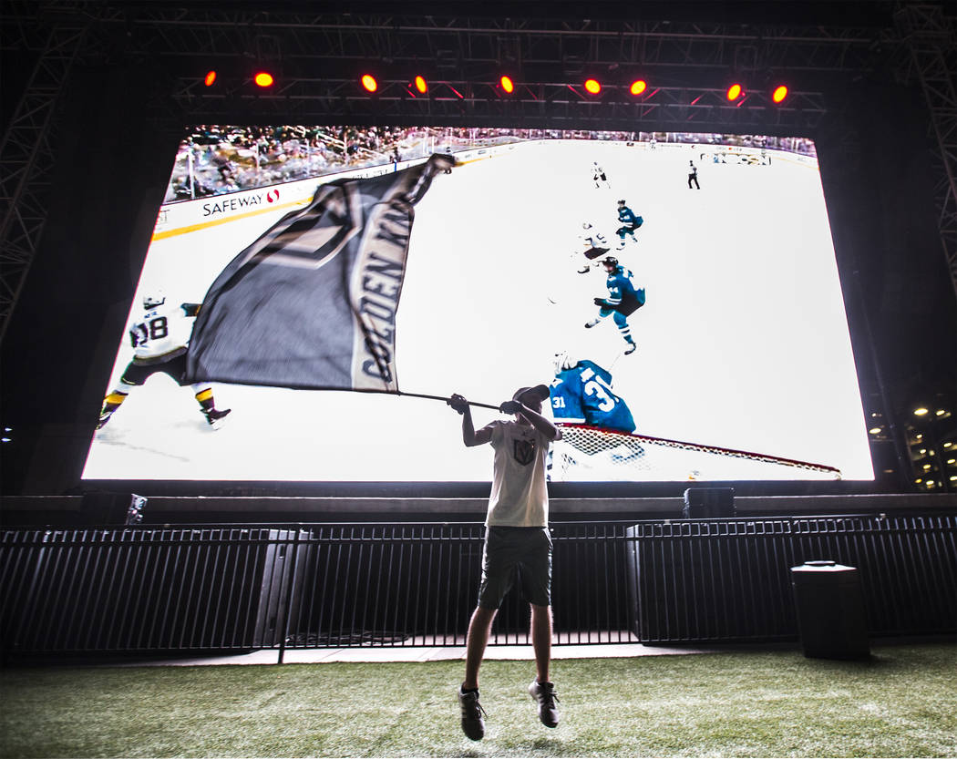 Golden Knights fan Matt Helfst waves his team's flag after a second period goal at a watch party during game three of Vegas' playoff series with the San Jose Sharks on Monday, April 30, 2018, at D ...