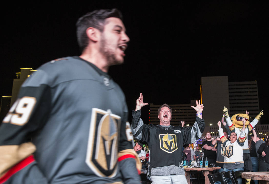 Golden Knights fan Rob Lawrence, middle, celebrates at a watch party after Vegas' Jonathan Marchessault scored an overtime goal to beat the San Jose Sharks 4-3 during game three of Vegas' playoff ...