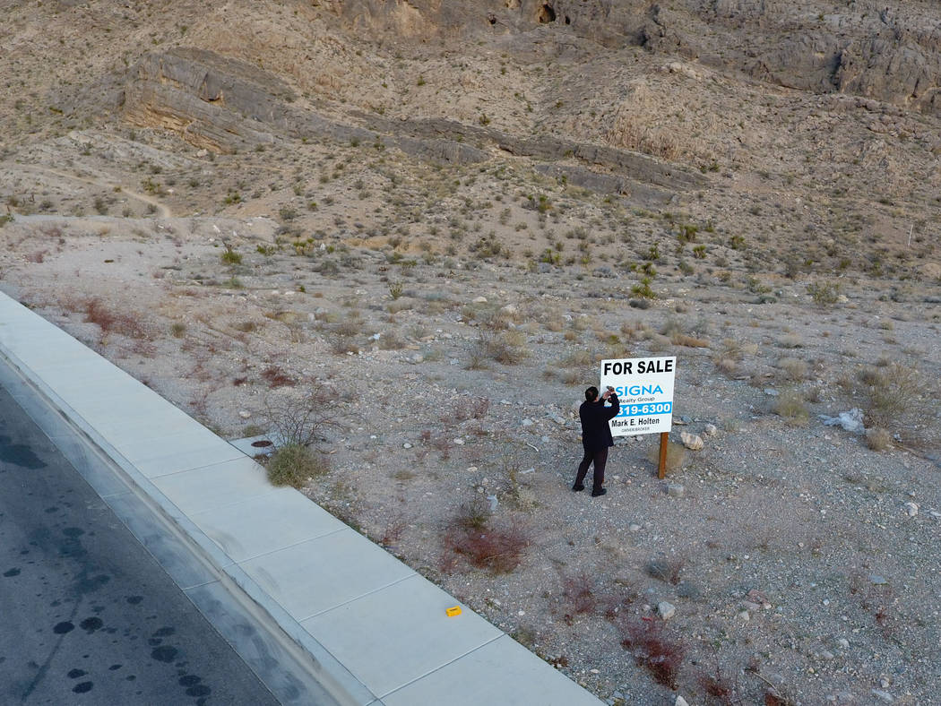 Property developer, Andy Pham, removes a For Sale sign from his property that was placed on after it was allegedly stolen using the Nevada secretary of state web site on Wednesday, March 28, 2018. ...