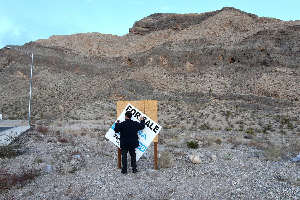Real estate investor Andy Pham removes a fraudulent "for sale" sign on his northwest Las Vegas property Jan. 30, 2018. Pham and his investors lost control of the multi-million dollar pro ...