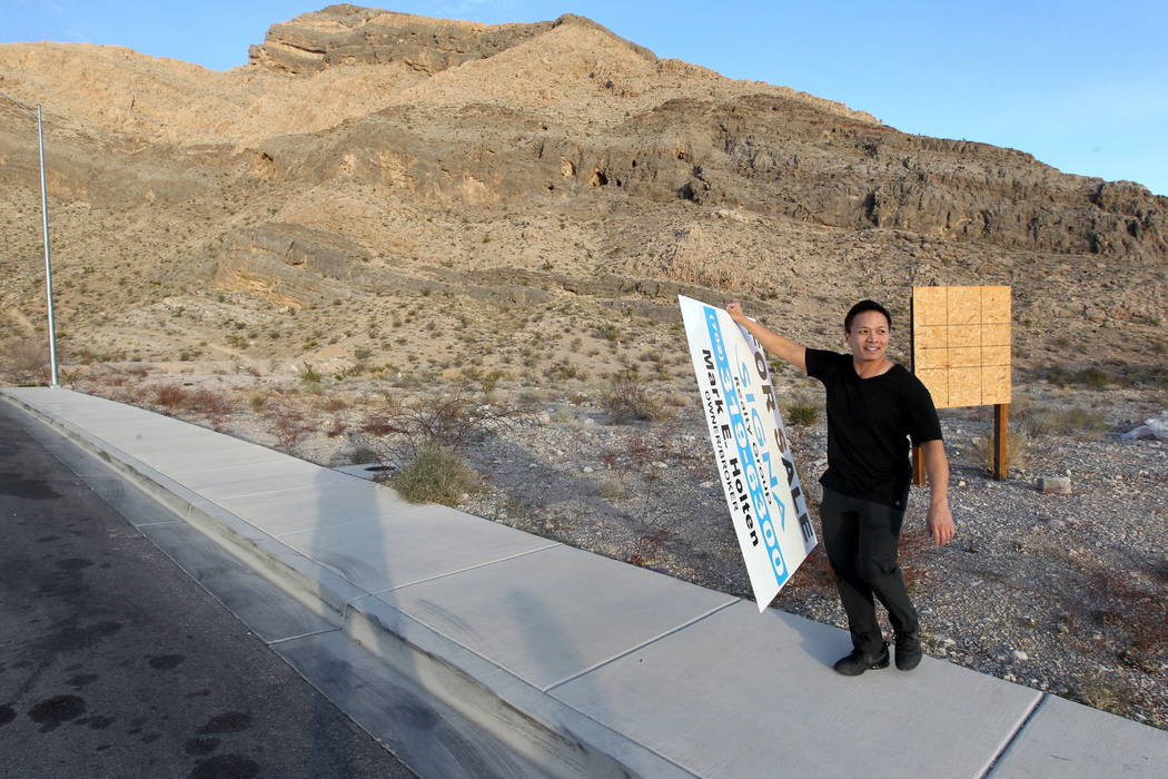 Real estate investor Andy Pham removes a fraudulent "for sale" sign on his northwest Las Vegas property Jan. 30, 2018. Pham and his investors lost control of the multi-million dollar pro ...