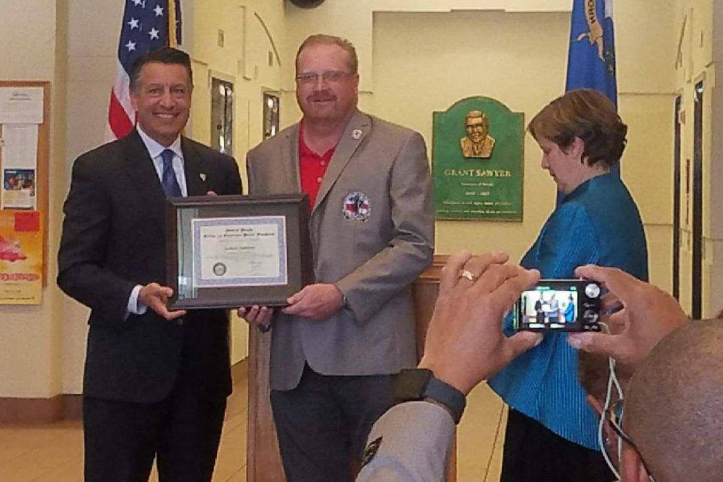 Rob Jackson (right) accepts the Veteran of the Month Award for April from Nevada governor Brian Sandoval. Courtesy photo.