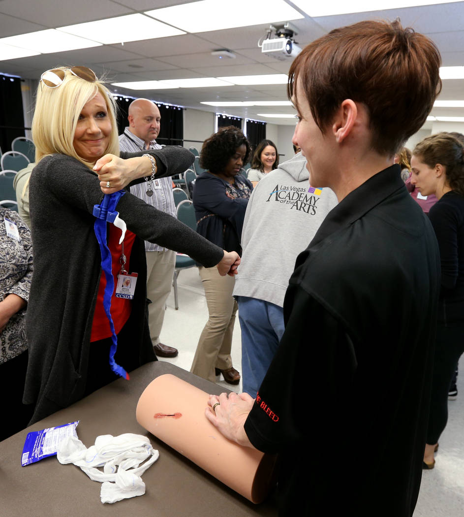 Las Vegas Academy Dance Instructional Assistant Brandi Nelson, left, learns how to apply a tourniquet with Brandy Castillo during University Medical Center "Stop the Bleed" training at t ...